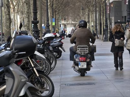 Un motociclista circula por la acera de la Diagonal de Barcelona. 