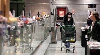 Varias personas hacen la compra en un supermercado en Madrid. 