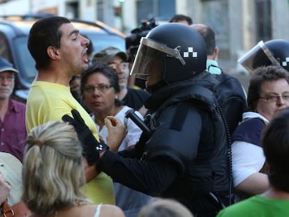 Un polic&iacute;a discute con un vecino que se opone al desalojo de una vivienda de la calle de Ofelia Nieto de Madrid, el pasado agosto.