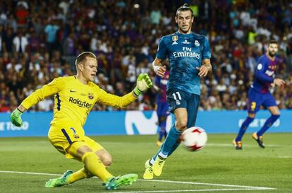 El portero alemán del FC Barcelona, Marc-André Ter Stegen, despeja el balón junto al delantero galés del Real Madrid, Gareth Bale.