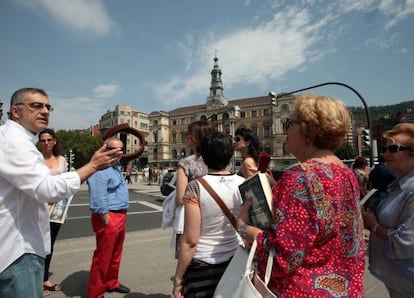 Félix G. Modroño, ayer con varios de los participantes en su recorrido guiado por Bilbao.