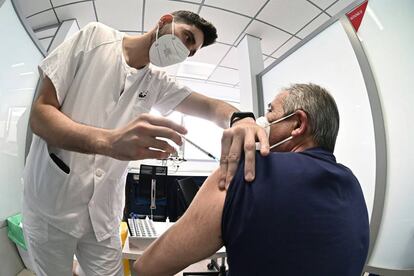 Un sanitario vacuna contra el coronavirus a un hombre en el hospital de Alcalá de Henares en Madrid.
 