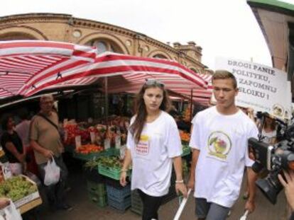 Dos jóvenes promocionan fruta polaca en Varsovia, en agosto.