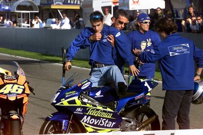 Dani Pedrosa, con muletas, es ayudado a subirse a su moto, antes del Gran Premio de la Comunidad Valenciana, celebrado en el circuito Ricardo Tormo de Cheste, el 2 de noviembre de 2003. 