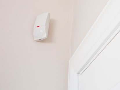 Plano detalle de un sensor de movimiento colocado al lado de la puerta.