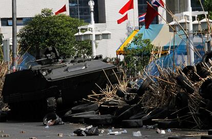 Un vehículo blindado del ejército tailandés destruye parte de las barricadas levantadas por los <i>camisas rojas</i> en el centro comercial y financiero en Bangkok.