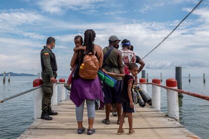 Migrantes en un muelle antes de abordar una embarcación en Necoclí, en agosto de 2021.