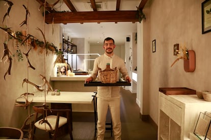 El chef Carlos Casillas, con una damajuana, en el restaurante Barro, Ávila.