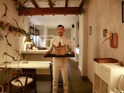 El chef Carlos Casillas, con una damajuana, en el restaurante Barro, Ávila.