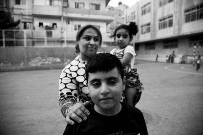 Una madre con sus dos hijos en el patio de recreo espera reunirse con sus compatriotas. En esta parroquia de Marqa, el padre Carlos, de Mensajeros por la Paz, ofrece refugio a quienes llegan sin nada. 