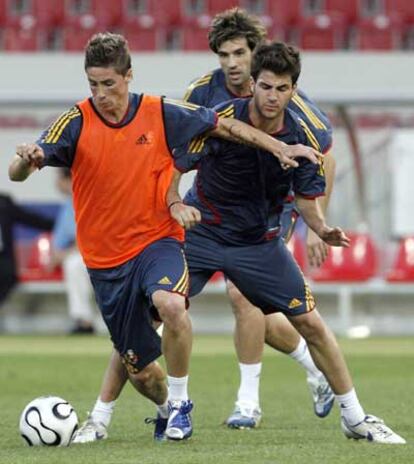 Torres protege el balón ante Cesc y Albelda,  durante el entrenamiento previo al choque ante Túnez.