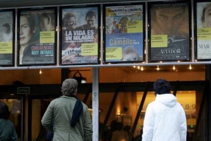 Dos personas contemplan la cartelera de un cine madrileño.