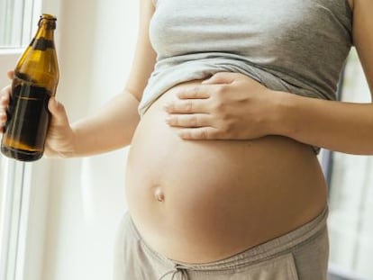 Una dona embarassada, amb una cervesa a la mà.