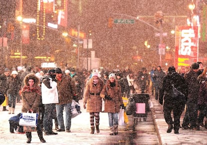 Pessoas passeiam sob a neve na Broadway, em Nova York.