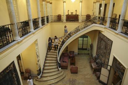 Escalera de acceso al piso superior donde se puede ver la galería donde estaban colgados parte de la colección de pintura de Julio Muñoz. La estancia se cubre con una claraboya con un vidriera original de la casa a la que se sustituyó la parte central para colocar las iniciales del apellido de Muñoz Ramonet