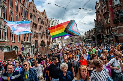 Miles de personas caminando, mientras sostienen banderas arcoíris durante el desfile Queer & Pride Amsterdam 2023, el 22 de julio.
