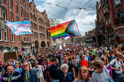 Miles de personas caminando, mientras sostienen banderas arcoíris durante el desfile Queer & Pride Amsterdam 2023, el 22 de julio.