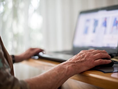 Una mujer mayor usa un portátil.