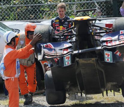 Vettel observa cmo retiran su monoplaza del circuito.