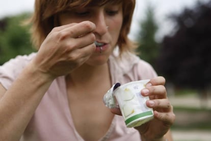 Una persona come un yogur con probióticos