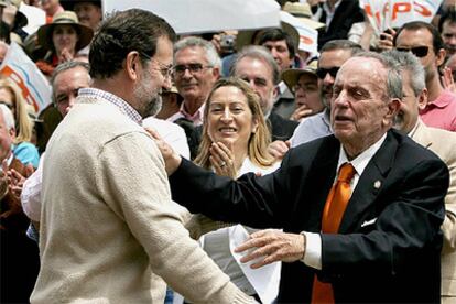 Rajoy abraza a Fraga mientras Ana Pastor aplaude durante la romería del PP de Galicia en el Monte do Gozo.