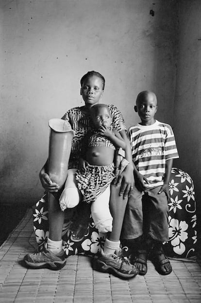 Sofia Elface Fumo, de 24 años, con sus hijos Leonaldo y Alia, en Massaca (Mozambique), en 2007. Sofia perdió las dos piernas por una mina antipersona.