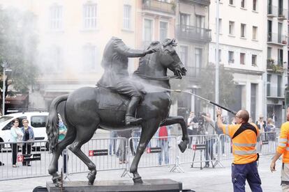 Uns operaris netegen l'estàtua de Franco decapitat, després que li hagin llançat ous.