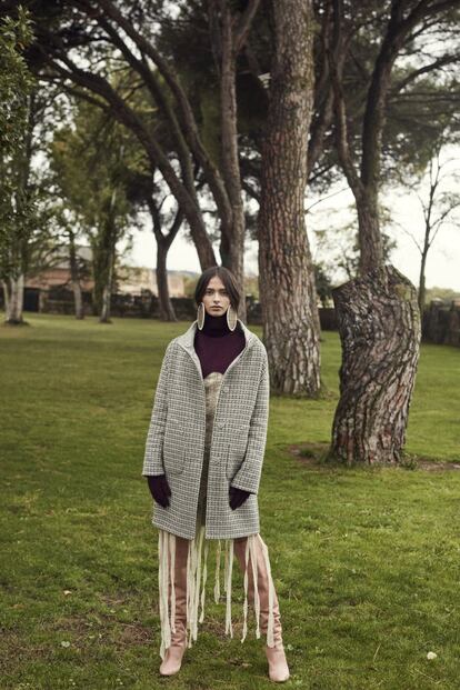 Ana lleva vestido de Herida de Gato, abrigo de Herno, cuello con guantes incorporados de Cos, botas de Aquazzura y pendientes de Loewe.