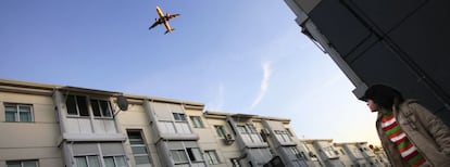 Un avión sobrevuela viviendas en San Fernando de Henares, localidad madrileña afectada por el ruido del aeropuerto de Barajas.  