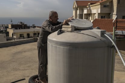 Mrad Mrad comprueba el depósito de agua en la azotea de su vivienda en la localidad de Aamchit, en el municipio de Byblos. Los cortes intermitentes de electricidad impiden el funcionamiento del motor que bombea el agua desde las tuberías hacia arriba para llenar los depósitos que la distribuyen a toda la casa.