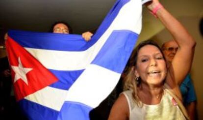 Unos cubanos con una bandera de la isla.