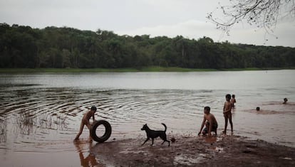 Crianças nadam no rio Paraná. A administração de Itaipu proibiu a comunidade de pescar na represa.