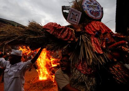 Un hombre carga con una efigie del demonio Ghantakarna, lista para ser quemada para simbolizar la destruccin del mal, durante el festival Ghantakarna en la antigua ciudad de Bhaktapur, Nepal.