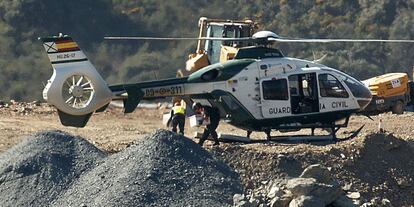 Un agente baja explosivos del helicoptero para los trabajos de excavación.