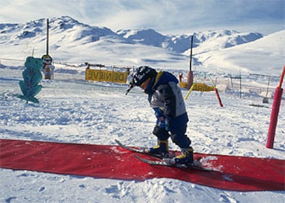 Un niño da sus primeros pasos con esquís en un jardín de nieve de Baqueira-Beret.
