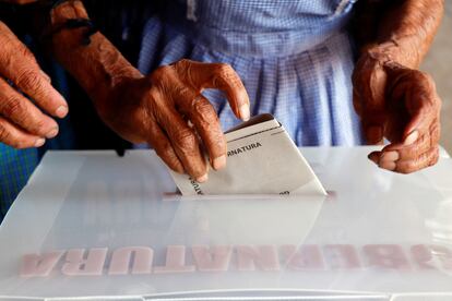 Una mujer emite su voto para la gubernatura de Oaxaca, durante las elecciones estatales, hoy, en el municipio de Santa María Atzompa.