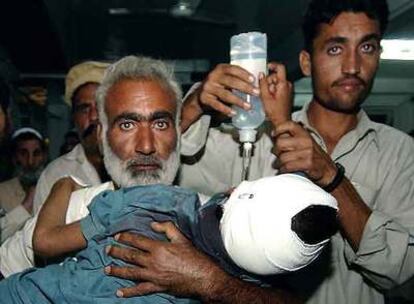 Evacuación de un niño herido ayer por una bomba en la ciudad paquistaní de Peshawar, vecina a las zonas tribales.