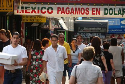 Un grupo de peatones circula por una populosa calle del barrio mexicano de Queens (Nueva York).