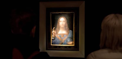 Varias personas observan la obra 'Salvator Mundi' del artista Leonardo da Vinci (1500), durante una vista previa pública antes de la subasta de Christie's en Nueva York.