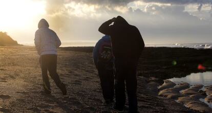 A group of men search for hash on a beach in Chiclana.