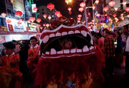 Una mujer disfrazada de dragón actúa durante las celebraciones en la víspera del Año Nuevo Lunar Chino, este lunes en Rangún (Birmania). 