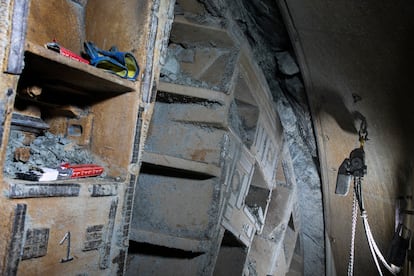 La rueda de corte de la tuneladora que agujerea el subsuelo de Barcelona y construye el futuro túnel de la L9 en su tramo central. Mide 12 metros de diámetro y la piedra que se observa sobre la estructura metálica es granito. La imagen fue tomada en marzo de 2023.
