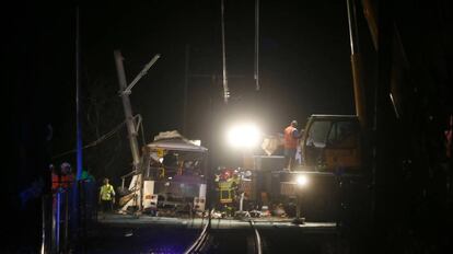 Bomberos, policía y personal de emergencias trabajan en el lugar del accidente, el paso a nivel de Millas.