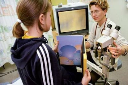 Una niña examina diagramas anatómicos poco antes de ser explorada por una médica en la Casa de los Niños de Islandia.