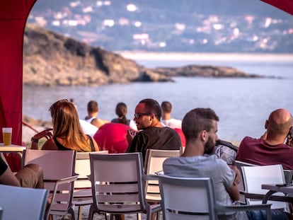 Un grupo de personas descansa en la terraza de un bar en el interior del festival.