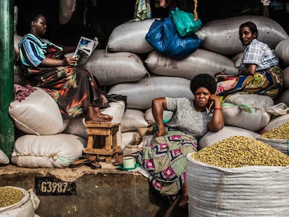 Tres señoras decansan en su puesto de venta de legumbres en Owino Market, Kampala (Uganda), en una imagen de Quico García.