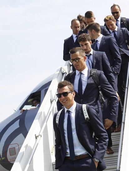 El delantero de la selección croata de fútbol, Mario Mandzukic, y sus compañeros durante la llegada del equipo al aeropuerto de Deauville, Francia. Los croatas han aterrizado en la ciudad francesa con un traje de calle más casual, de corbata estrecha y sin el escudo en la solpa.