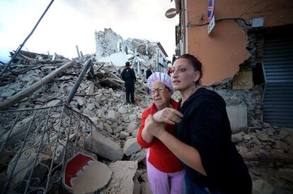 Dos mujeres observan las casas derrumbadas en Amatrice debido al terremoto.