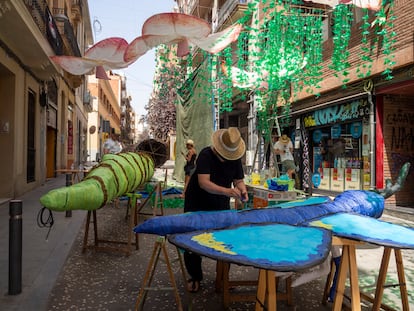 Preparativos de las Fiestas de Gràcia de Barcelona. En la imagen, vecinos de la calle de Verdi trabajando en pleno mediodía.