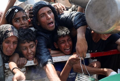 Varias personas gritan para recibir comida en Ciudad de Gaza, este sábado.